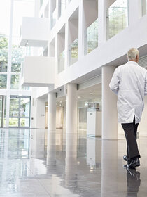 Two men in lab coats walking through a foyer
