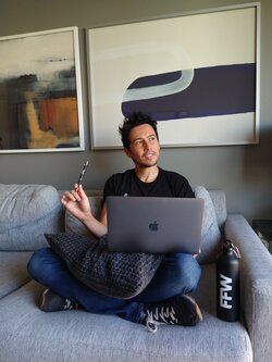 Man with FFW shirt sitting on couch with laptop