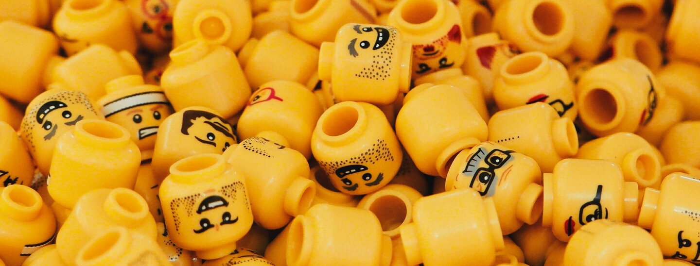 Image of pile of yellow lego heads with different expressions