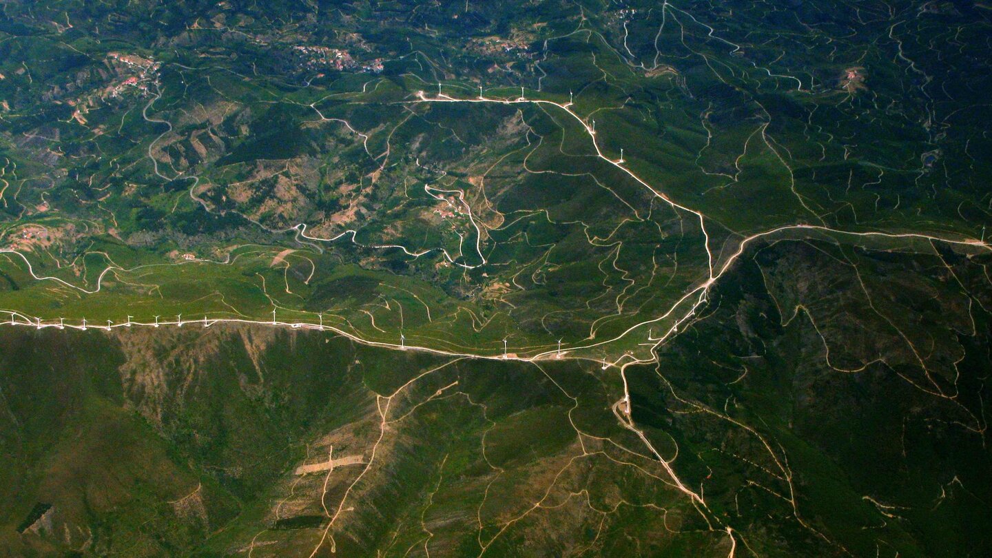 An aerial view of roads stretching across green hills